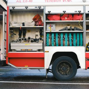 Close-up of a fire truck's open compartment showing firefighting tools.