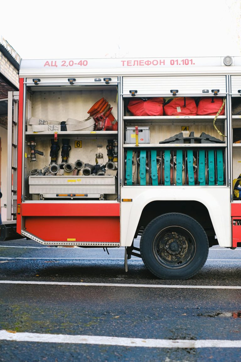 Close-up of a fire truck's open compartment showing firefighting tools.