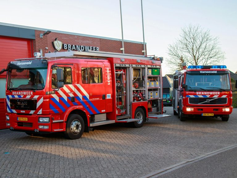 Fire trucks parked outside Varsselveld fire station on a clear day.